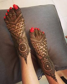 the feet are decorated with henna and red nail polish