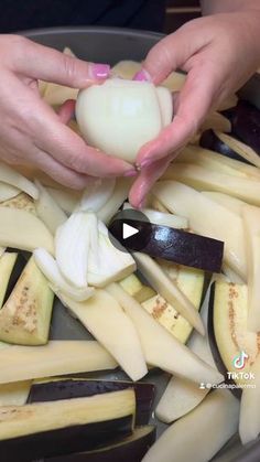 someone is peeling an onion into pieces in a bowl with other ingredients on the side