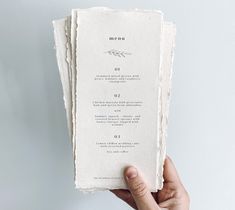 a person holding up a menu card in their left hand, with the word menu printed on it