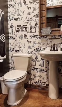 a bathroom with a toilet, sink and wallpaper in black and white color scheme