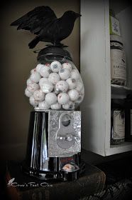 a black bird sitting on top of a machine filled with balls