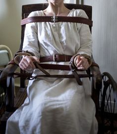 a woman sitting in a chair with her hands on the straps