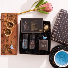 an assortment of items from the zodiac sign collection on display in a box next to a pink flower