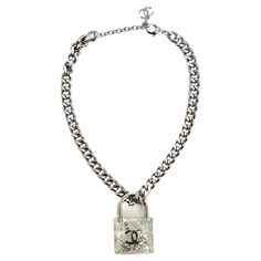 Introducing the Chanel 2014 CC Plexiglass Padlock Necklace, a bold and playful statement piece that exudes luxury and sophistication. This thick silver-tone chain necklace features a large plexiglass padlock filled with silver-tone beads and faux pearls, creating a captivating and dynamic design. At the center of the padlock is a striking silver-tone CC logo, showcasing the iconic Chanel emblem in a modern and innovative way. The necklace is complete with a lobster clasp closure and a CC Chanel Luxury Necklace With Square Pendant And Adjustable Chain, Luxury Square Pendant Jewelry With Adjustable Chain, Chanel Silver Necklace, Chanel Necklace Silver, Bottega Veneta Heels, Chanel Lock Necklace, Chanel 2014, Givenchy Handbags, Padlock Necklace