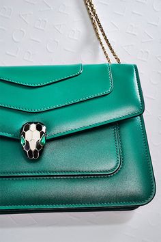 Marked by an urban lifestyle and a trendy wearability, the new “Serpenti Forever” crossbody bag brings a cool touch to the Serpenti universe. Crafted in emerald green calf leather, this model features light gold-plated brass hardware. The iconic snake head closure hypnotizes with black and white agate enamel and seductive eyes in green malachite. Perfect to accessorize a fashionable daywear look, the bag features a sinuous and adjustable snake body-shaped chain with a leather strap. Luxury Green Bag With Silver-tone Hardware, Luxury Green Shoulder Bag For Evening, Luxury Green Formal Shoulder Bag, Elegant Green Shoulder Bag With Palladium Hardware, Luxury Green Bags, Elegant Green Bags With Silver-tone Hardware, Elegant Green Bag With Palladium Hardware, Elegant Green Bag With Magnetic Closure, Green Leather Bag For Everyday Luxury