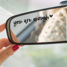 a woman's hand holding up a mirror with the words you are enough written on it