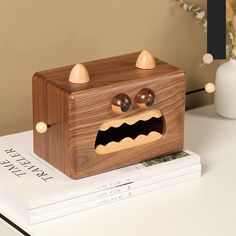 a wooden toy that looks like a toaster with eyes and mouth