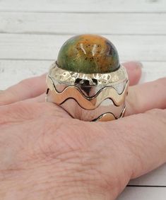 We present to you a beautiful, one of a kind, handmade Dian Malouf Multi Color Jasper Sterling Silver and 14k Gold accent Dome Ring. This is one of her early rings made in 1996. This ring features a huge Dome shaped Jasper cabochon that looks like a planet, measuring 23mm x 13mm. This is one of Dians coveted, super large and truly unique rings, as only one was ever made.  Ring Size: 6.75 Width: 31mm wide at the widest point X 43mm tall, and stands 25mm tall above the finger. Hallmarked: DLM Weight: 61.5 Grams!  We gladly combine shipping! Everything is packed with care to make sure it arrives safely.  We hunt the globe for wonderful treasures that we can present to you!  We only sell authentic items. If it is a name brand item we guarantee it to be authentic. If it is made of precious meta Luxury Sterling Silver Dome Ring With Round Band, Luxury Silver Wide Band Dome Ring, Luxury Sterling Silver Round Dome Ring, Luxury Sterling Silver Dome Ring With Polished Finish, Luxury Unique Sterling Silver Dome Ring, Luxury Sterling Silver Dome Ring With Gemstone, Luxury Gold Dome Ring In Sterling Silver, Luxury Unique Silver Dome Ring, Luxury Modern Sterling Silver Dome Ring