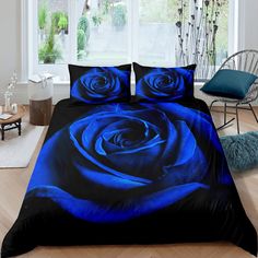 a bed with blue roses on it in front of a window