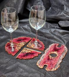 three wine glasses and two coasters on a black cloth