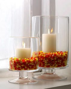 two glass vases filled with candy corn