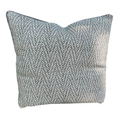 a blue and white pillow with an arrow pattern on the front, sitting on a white background