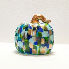 a colorful glass pumpkin sitting on top of a table