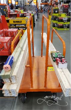 a wooden cart with two hand rails on it in a store filled with boxes and other items