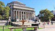 a fountain in front of a large building with columns