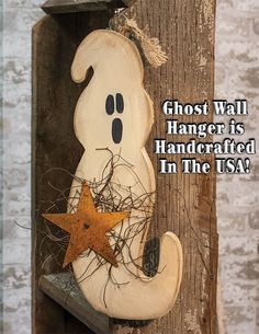 a wooden sign with a ghost hanging from it's side and the words, ghost wall hanger is handcrafted in the usa