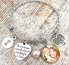 Grandma gift from granddaughter- Custom Photo Jewelry for Mother's Day- A Personalized The love between a Grandmother and Granddaughter is Forever Bangle Bracelet. A twisted bangle bracelet that comes with 1 round photo pendant. It also includes a family tree charm, one round letter charm, and a The love between a Grandmother and granddaughter (or grandson) is forever charm. *Please note: If there is no color change specified for your photo when ordering, the photo will remain in the color schem Grandmother And Granddaughter, Grandma Photos, Angel Wings Jewelry, Personalised Bangle, Twisted Bangle, Godmother Gifts, Forever Jewelry, Photo Pendant, Letter Charm