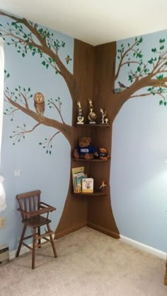 a child's room with a tree painted on the wall and shelves for books