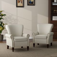 two white chairs sitting next to each other in a living room