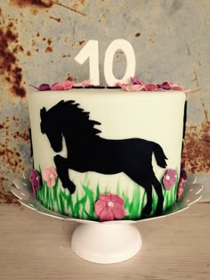 a birthday cake decorated with a horse and flowers