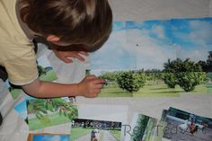 a young boy is looking at pictures on the floor