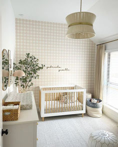 a baby's room with a white crib and beige wallpaper