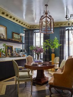 a living room filled with furniture and a chandelier hanging from the ceiling over a table