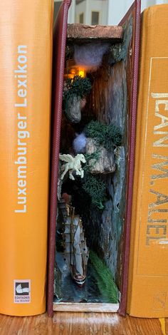 an open book shelf with books on top of it and a statue in the middle