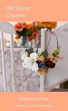 a white chair with flowers hanging from it's back legs and on the seat