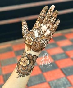 the hand is decorated with henna and flowers