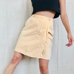 "Vintage Peach Wrap Mini Skirt Size Small Adorable skirt with two front Buttons and Double Pockets on Back Modeled on a Size Small 28\"Waist 38\"Hip 20\"Length 100% Cotton" High-waist Beige Cargo Skirt For Spring, High Waist Beige Cotton Cargo Skirt, High Waist Beige Cargo Skirt For Spring, Casual Knee-length Skort For Spring, Casual Knee-length Skort For Summer, Spring Knee-length Lined Skort, Summer Cotton Knee-length Mini Skirt, Knee-length Cotton Mini Skirt For Summer, Cotton Knee-length Mini Skirt For Summer