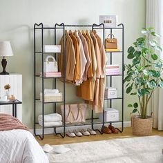 an iron rack with clothes and shoes on it in a bedroom next to a bed