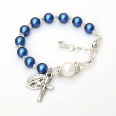 This beautiful rosary bracelet features glowing iridescent dark blue and white Swarovski crystal pearls and sparkly clear Swarovski crystals. All of the pearls and crystals are genuine Swarovski crystal. ✻ 6mm iridescent dark blue pearls represent the Hail Mary prayers. ✻ 8mm iridescent Swarovski white pearl represent the Our Father prayer; accented by clear crystal rhinestones on each side. ✻ Pearls are separated by smaller Swarovski diamond-shaped crystals in a sparkly finish. I hand-wrap a sp Blue Spiritual Jewelry For First Communion, Mary Prayers, Beautiful Rosary, Blue Pearls, Shaped Crystals, Rosary Bracelet, Baptism Girl, Hail Mary