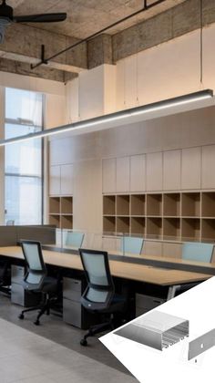 an empty conference room with desks and chairs in it, along with shelves on the wall