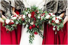 the bridesmaids are holding their bouquets with red and white flowers on them