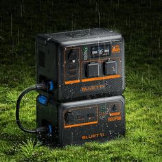 two electronic equipment sitting in the grass with rain coming down on it's sides