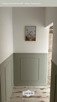 an empty room with white walls and green paneling on the wall, in front of a door