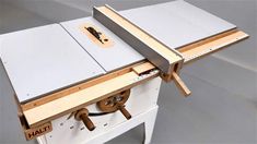 a table sawing on top of a piece of wood with two pieces of plywood attached to it