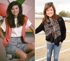 two women are posing next to each other in front of a fence and one is wearing a scarf