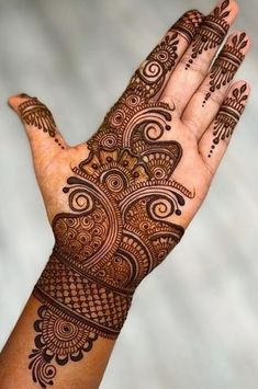 a hand with henna on it that is showing the intricate pattern and design,