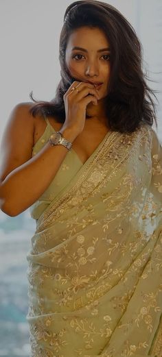 a woman in a sari posing for the camera with her hand on her mouth