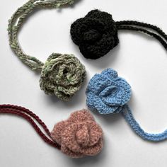 four crocheted flower headbands on a white surface with one knot in the middle