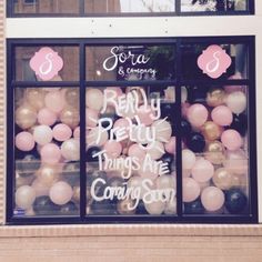 there is a store front with balloons in the window