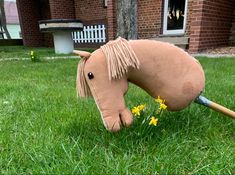 a fake horse head in the grass with flowers growing out of it's mouth