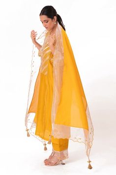 Golden yellow kurta featuring a round notched neckline and three-quarter sleeves with zardosi embroidery on the banarasi jacquard tissue yoke. Paired with a cotton slub silk pant and a chanderi dupatta with scalloped tissue detailing., Fit: Relaxed Floral Pant, Zardosi Embroidery, Yellow Kurta, Chanderi Dupatta, Silk Pant, Notched Neckline, Women Kurta, Straight Kurta, Kurta With Pants