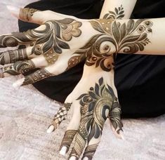 two hands with henna tattoos on them