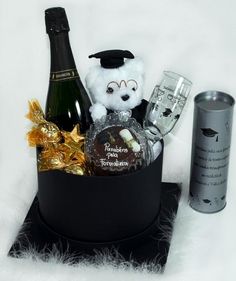 a teddy bear in a black box with champagne and chocolates