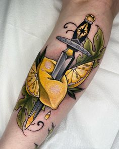 a tattoo on the leg of a person with a knife and lemons in it