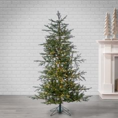 a small christmas tree sitting in front of a white brick wall next to a fireplace