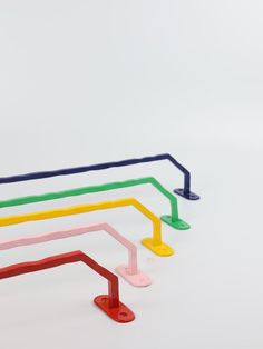 four different colored plastic objects on a white surface